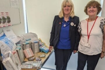 A picture of Tricia Glenister from Tesco, Jarman Park, and Rosemary Hall of Dacorum Community Trust receiving bedding items donated by Tesco
